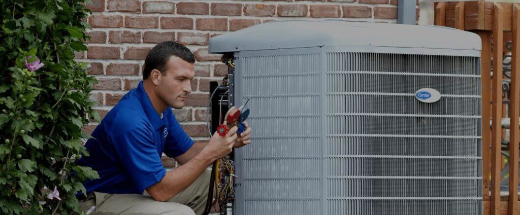 A man working on an air conditioner unit.